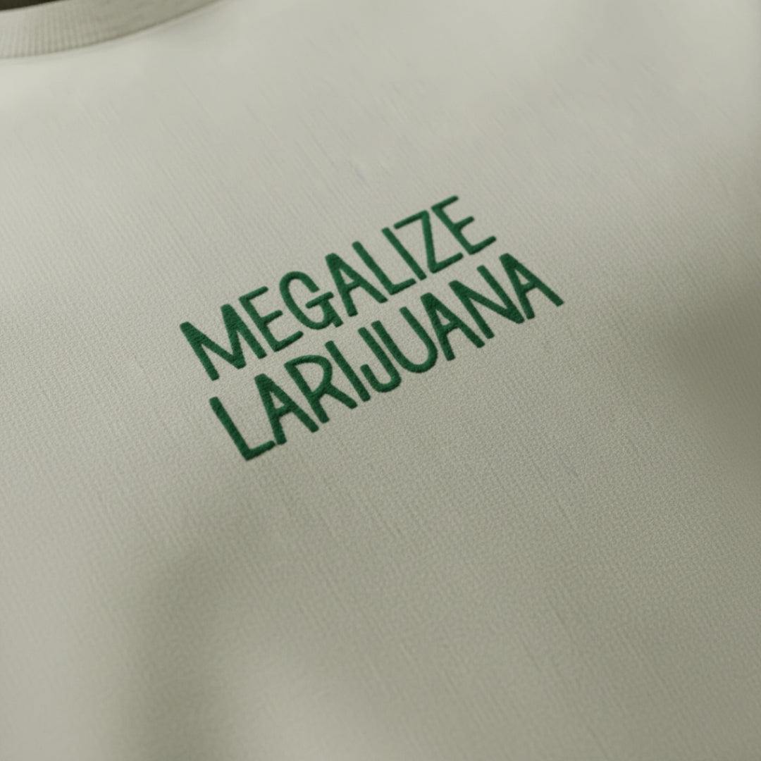 spankers weed tshirt Text 'MEGALIZE LARIJUANA' on a beige background