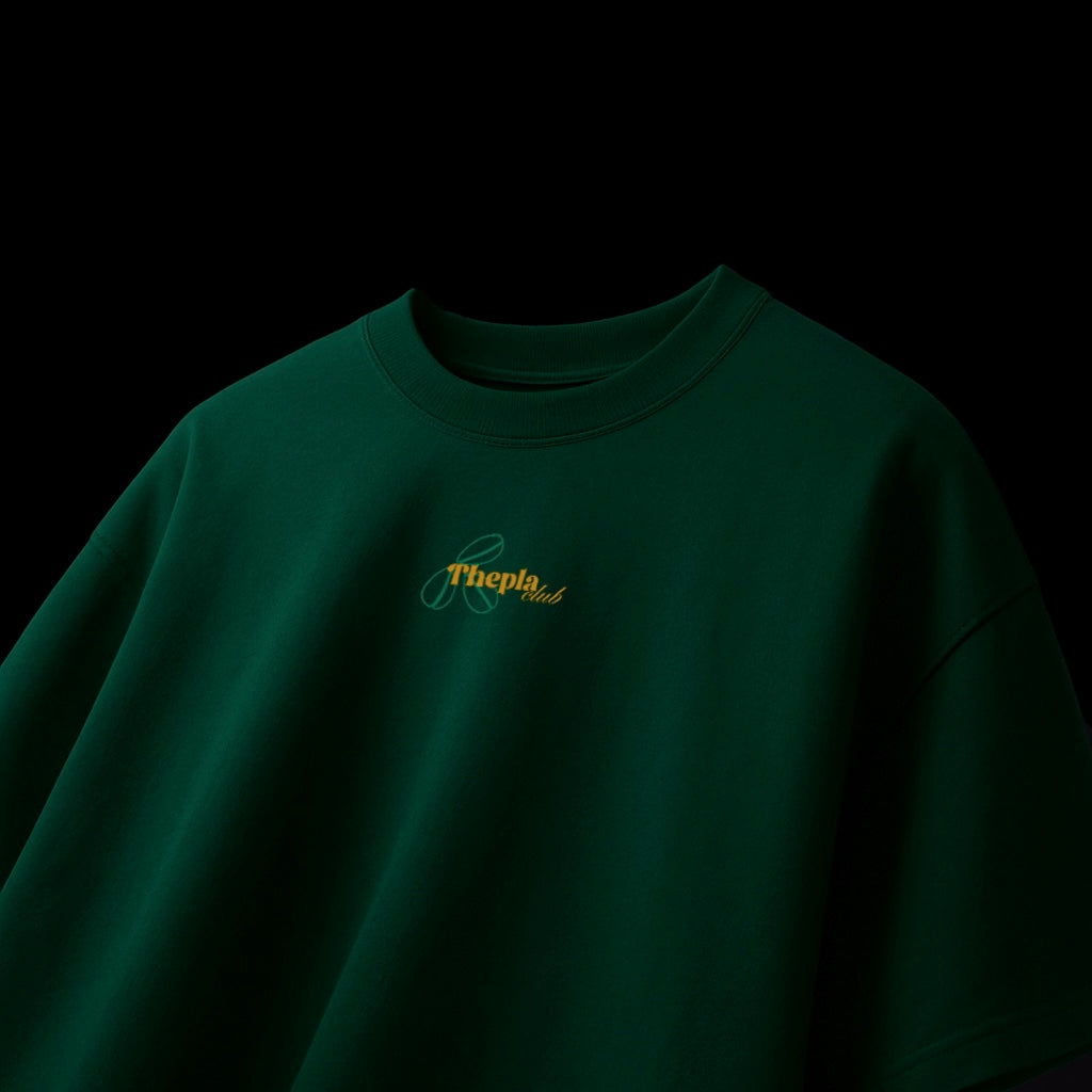 spankers Green ttshirt with a logo on the chest against a black background thepla club 