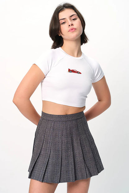spankers Person wearing a white crop top with a red design and a pleated gray skirt on a white background