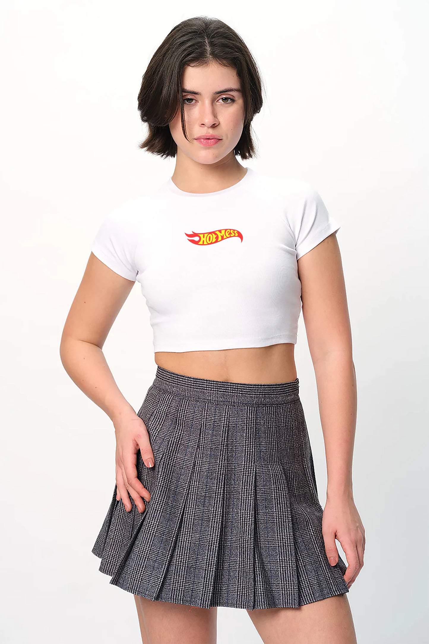 spankers Woman wearing a white crop top with a logo and a pleated skirt on a white background
