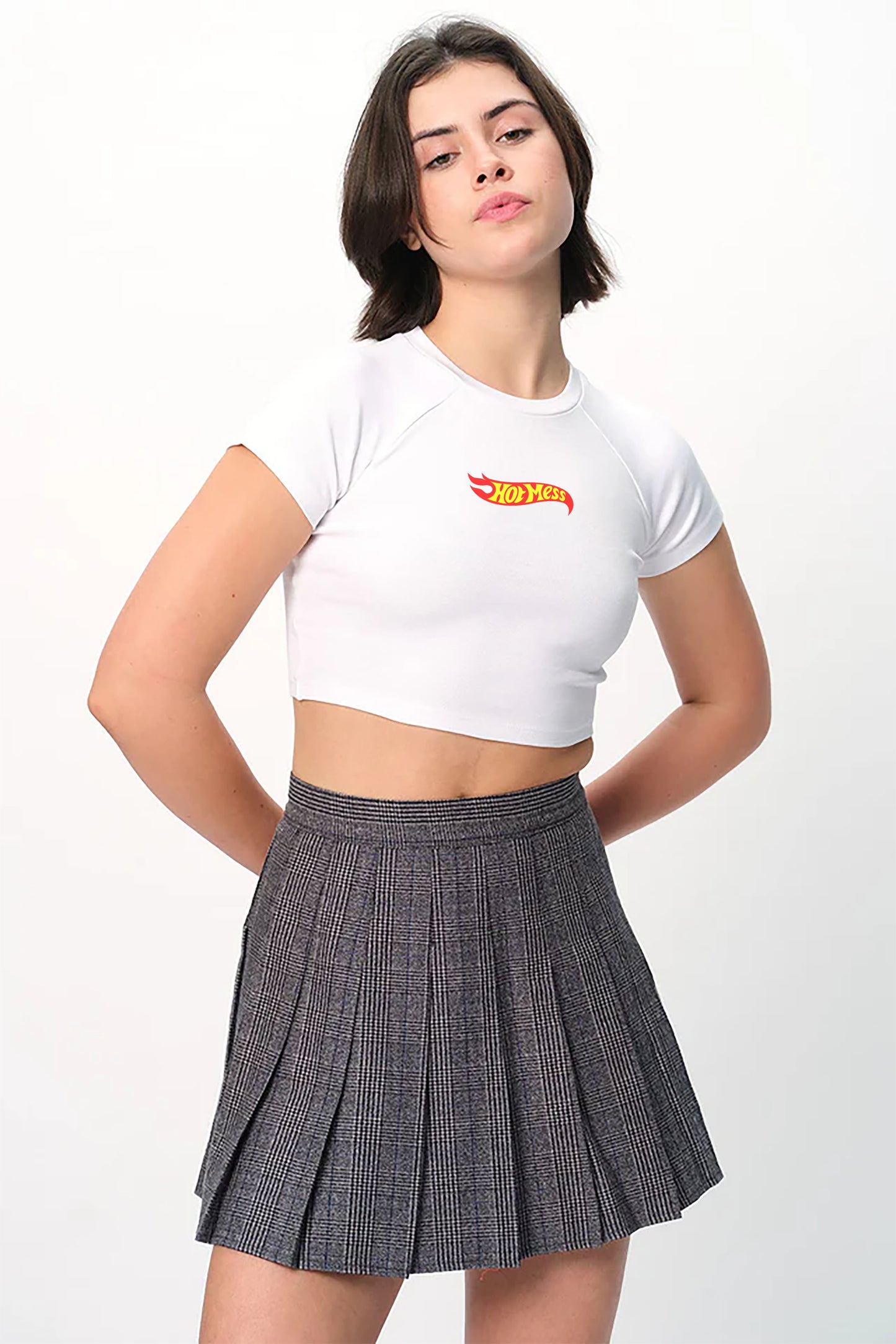spankers Person wearing a white crop top with a logo and a pleated skirt on a white background