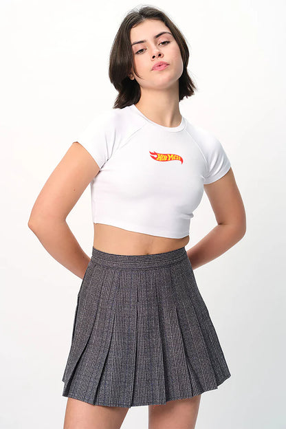 spankers Person wearing a white crop top with a logo and a pleated skirt on a white background