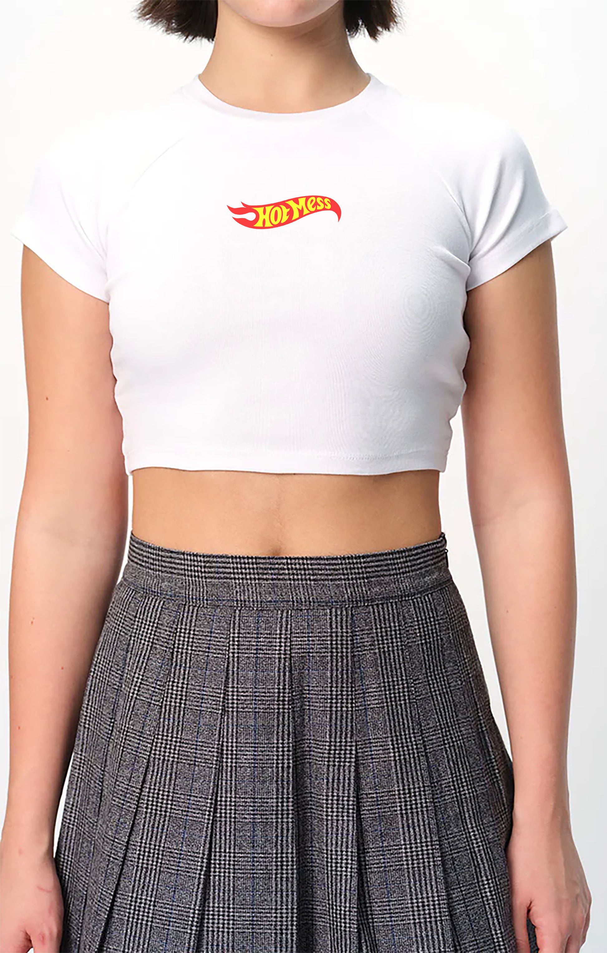 spankers Person wearing a white crop top with a red and yellow hot messc  and a plaid skirt.